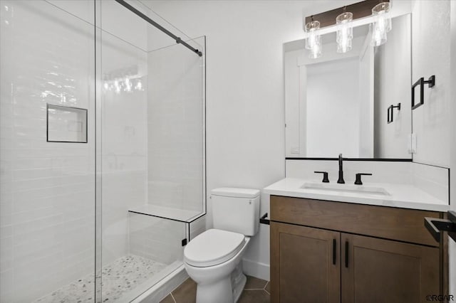 bathroom featuring vanity, tile patterned flooring, toilet, and walk in shower