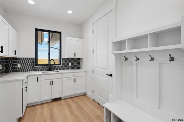 mudroom with sink and light hardwood / wood-style floors