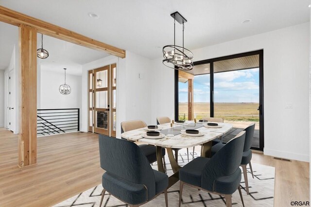 dining space featuring light hardwood / wood-style floors and a notable chandelier