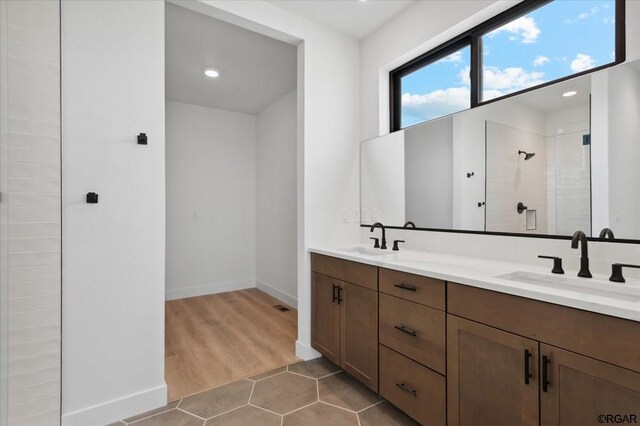 bathroom featuring tile patterned flooring, vanity, and walk in shower