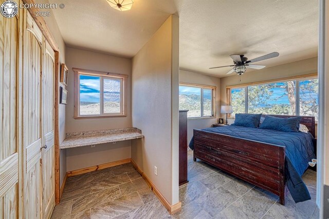 820 Little Horn Dr, Westcliffe, CO 81252 - bedroom with stone tile floors, a ceiling fan, and baseboards