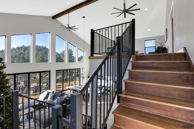 stairs featuring beamed ceiling, ceiling fan, and high vaulted ceiling