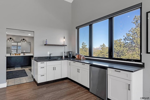 kitchen with dark hardwood / wood-style flooring, sink, white cabinets, and refrigerator