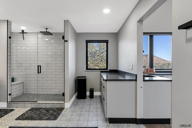 bathroom featuring vanity, a shower with shower door, and tile patterned floors