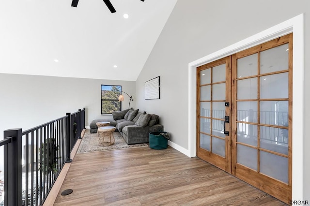 living room with wood-type flooring, ceiling fan, high vaulted ceiling, and french doors