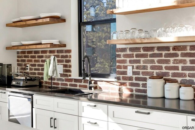 kitchen with white cabinetry, dishwasher, and sink