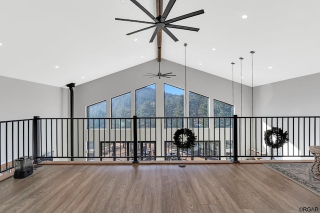 interior space featuring hardwood / wood-style flooring, ceiling fan, beam ceiling, and high vaulted ceiling