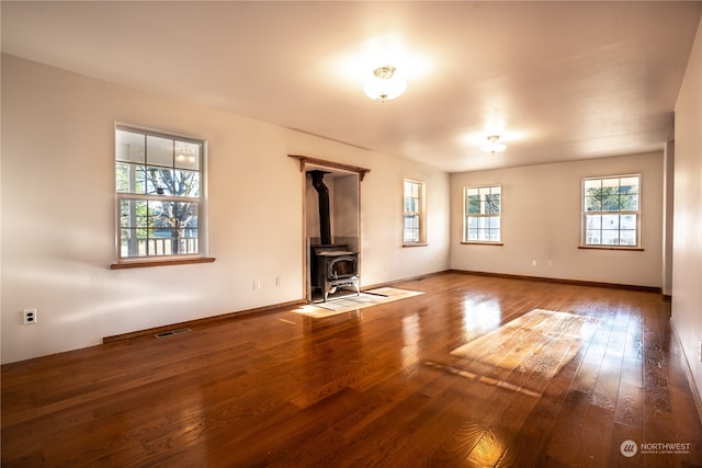 unfurnished living room featuring dark hardwood / wood-style flooring and a wood stove