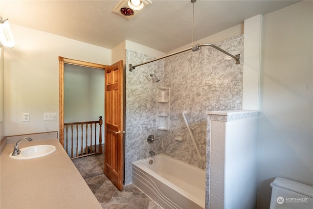 full bathroom with toilet, tiled shower / bath combo, a textured ceiling, vanity, and tile flooring