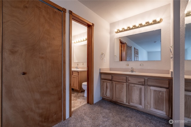 bathroom with tile flooring, toilet, and vanity