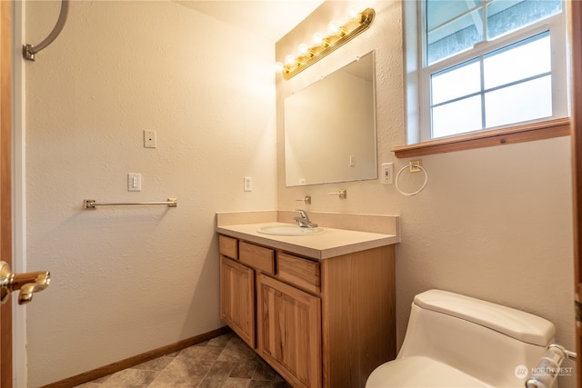 bathroom with toilet, tile floors, and vanity with extensive cabinet space