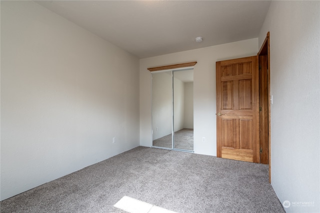 unfurnished bedroom with a closet and carpet floors