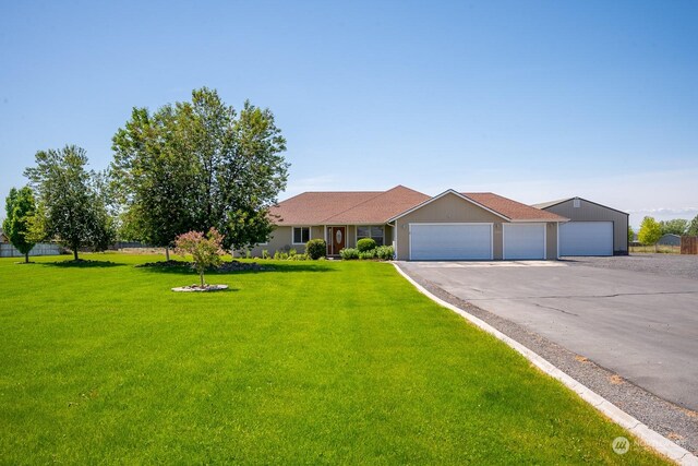 single story home with a garage and a front yard