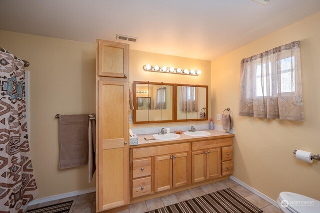 bathroom featuring tile patterned flooring, vanity, and toilet