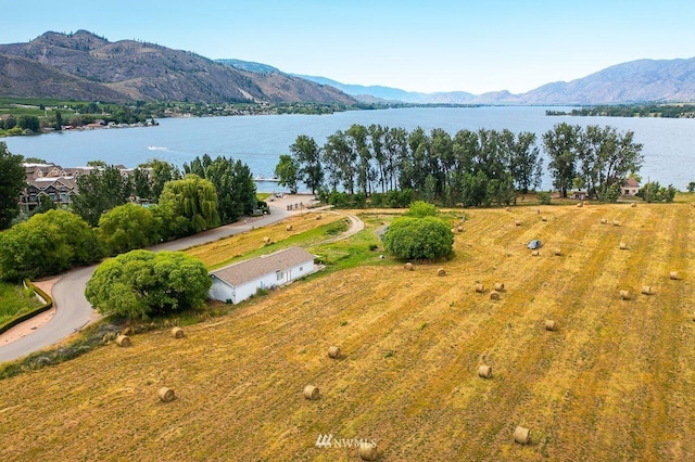 drone / aerial view featuring a water and mountain view