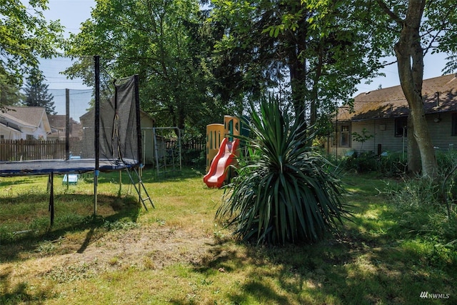 view of yard featuring a trampoline and a playground