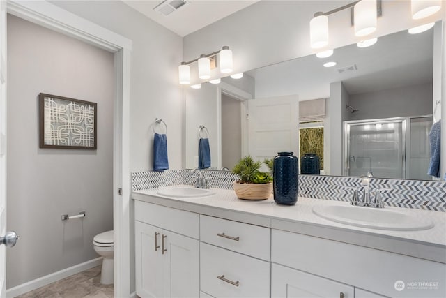 bathroom featuring toilet, an enclosed shower, and vanity