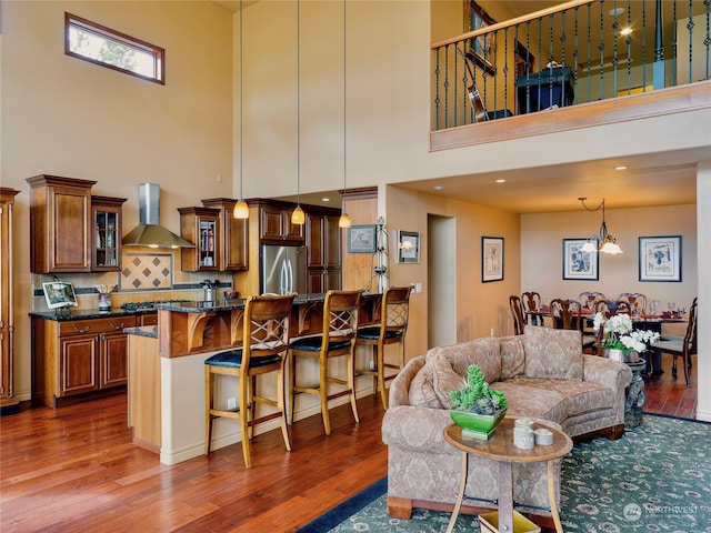 living room with dark hardwood / wood-style floors, a chandelier, and a towering ceiling