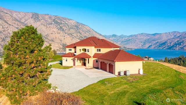 view of front facade with a mountain view, a front lawn, and a garage