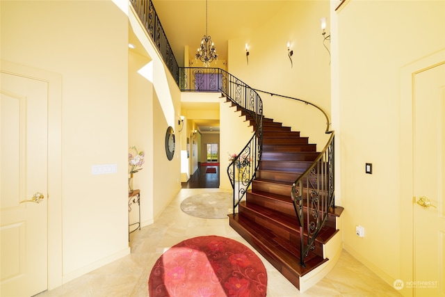 stairs featuring a high ceiling, light tile flooring, and an inviting chandelier