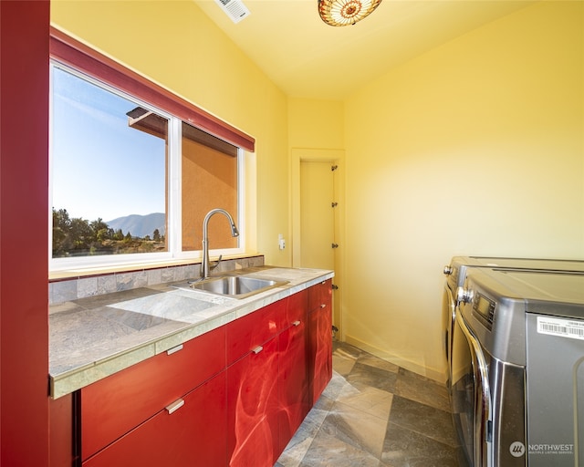 laundry room featuring cabinets, a mountain view, sink, washer and clothes dryer, and dark tile flooring