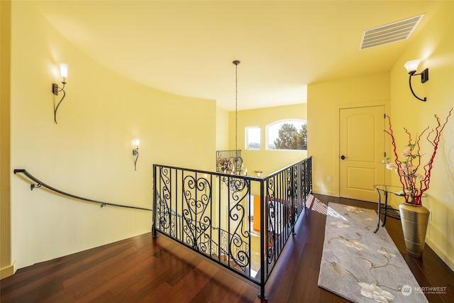 hallway featuring a notable chandelier and dark hardwood / wood-style floors