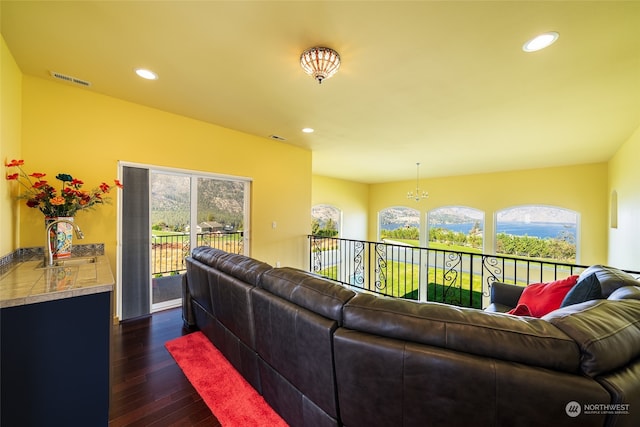 living room featuring dark hardwood / wood-style floors, an inviting chandelier, sink, and a wealth of natural light