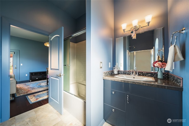 bathroom featuring tile floors, bath / shower combo with glass door, and vanity with extensive cabinet space