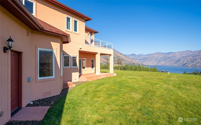 view of yard featuring a patio area and a water and mountain view