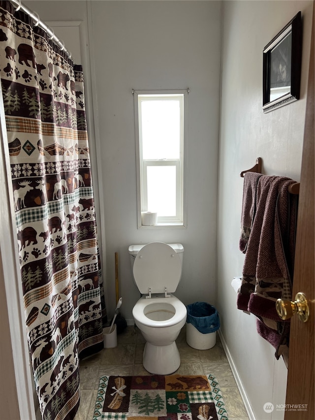 bathroom featuring toilet and tile floors