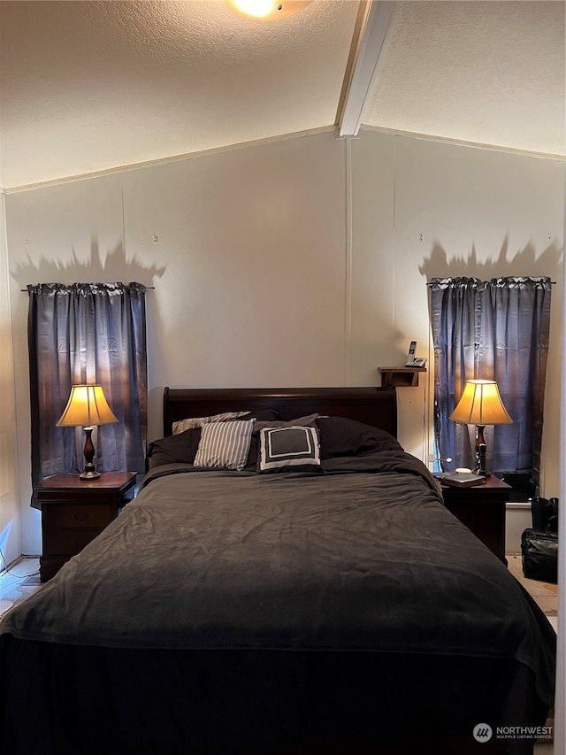 bedroom with lofted ceiling with beams and a textured ceiling