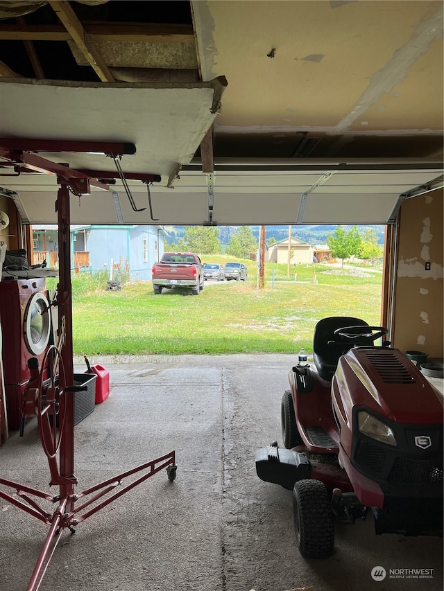 garage with washing machine and clothes dryer and a yard