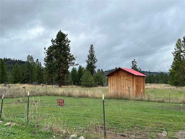 view of yard featuring a rural view and a storage shed