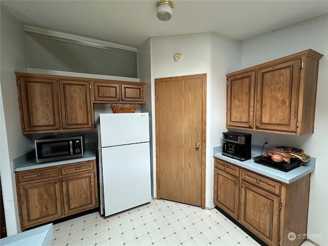 kitchen with light tile flooring and white refrigerator