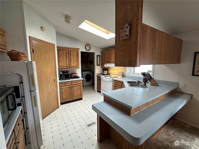 kitchen featuring washer / clothes dryer, electric stove, light tile floors, and vaulted ceiling