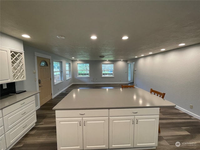 653 Sunset Ave NE, Ocean Shores, WA 98569 - kitchen featuring white cabinetry, dark hardwood / wood-style floors, and a kitchen island