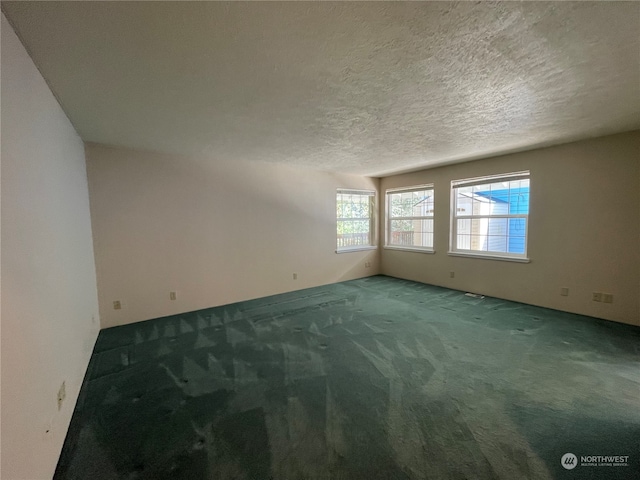 653 Sunset Ave NE, Ocean Shores, WA 98569 - spare room with dark carpet and a textured ceiling