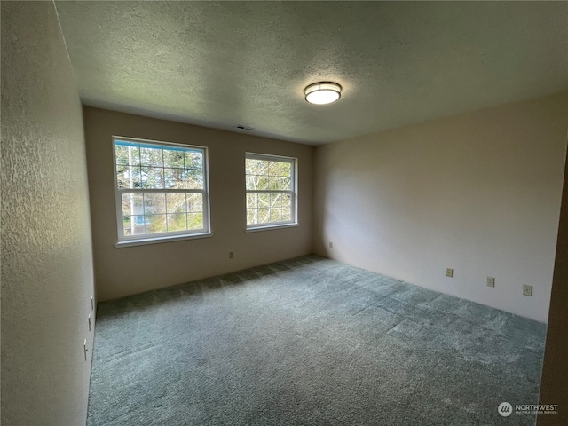 653 Sunset Ave NE, Ocean Shores, WA 98569 - unfurnished room with a textured ceiling and dark carpet