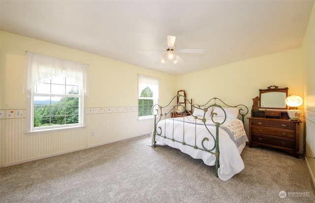 carpeted bedroom with ceiling fan and multiple windows