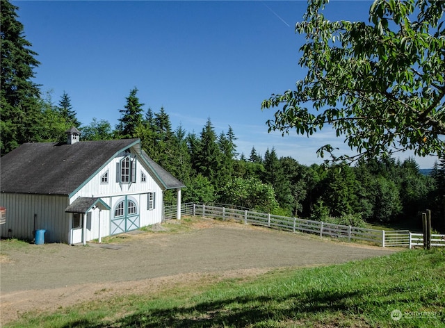 exterior space featuring a rural view and a yard