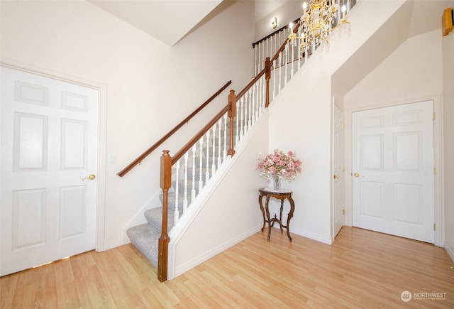 stairs featuring light hardwood / wood-style floors and high vaulted ceiling