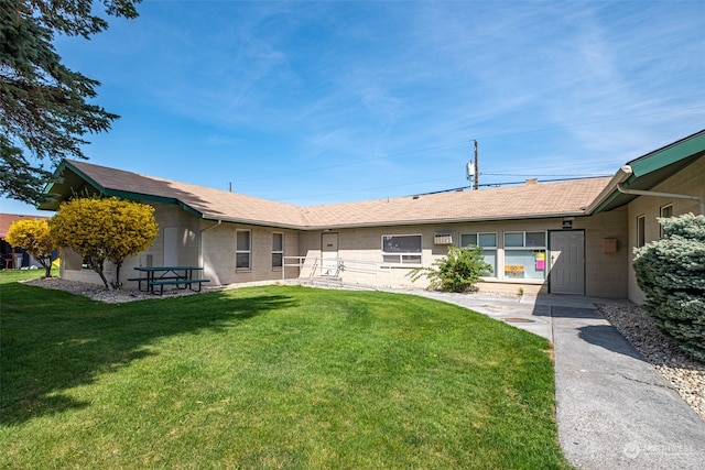 rear view of house featuring a lawn