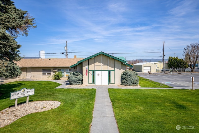 view of front of home with a front lawn and a garage