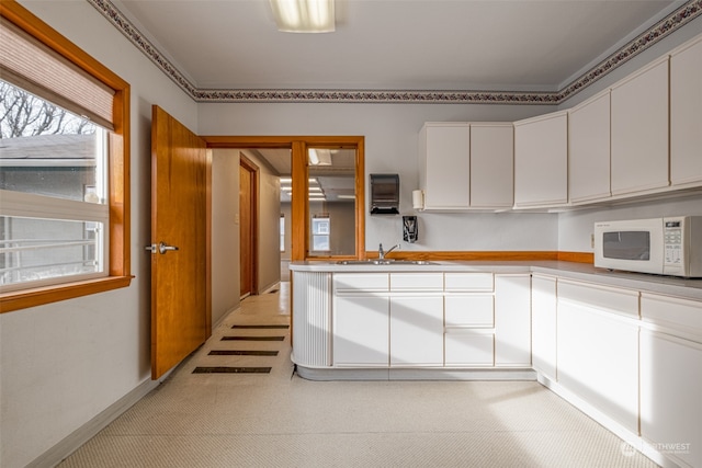 kitchen featuring white cabinetry and sink