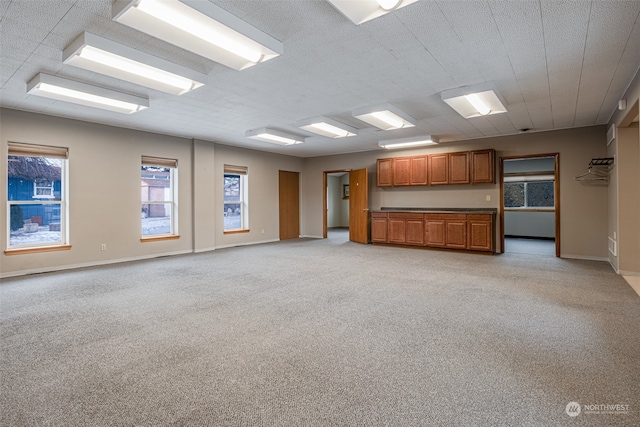 unfurnished living room featuring light carpet