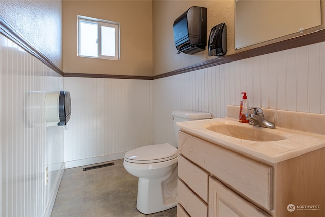 bathroom with tile floors, vanity with extensive cabinet space, and toilet