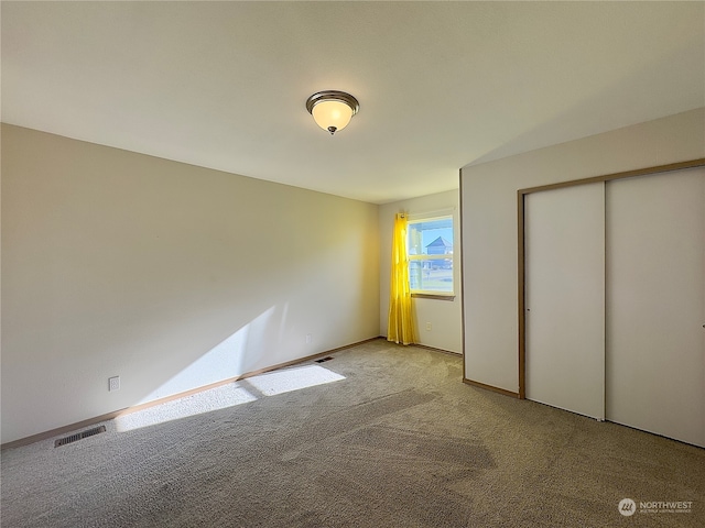 unfurnished bedroom with light carpet and a closet