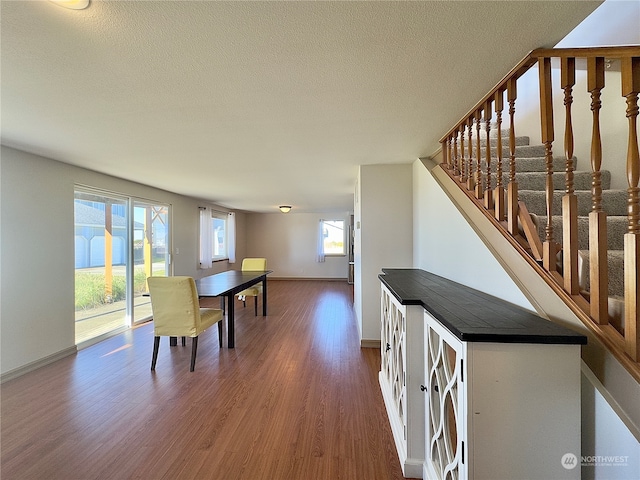 dining room featuring dark hardwood / wood-style flooring and a textured ceiling