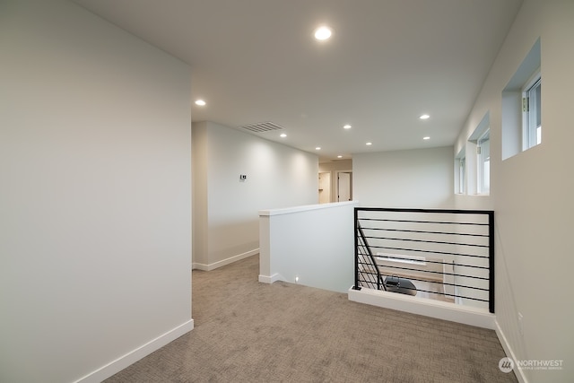 hallway featuring recessed lighting, an upstairs landing, baseboards, visible vents, and carpet