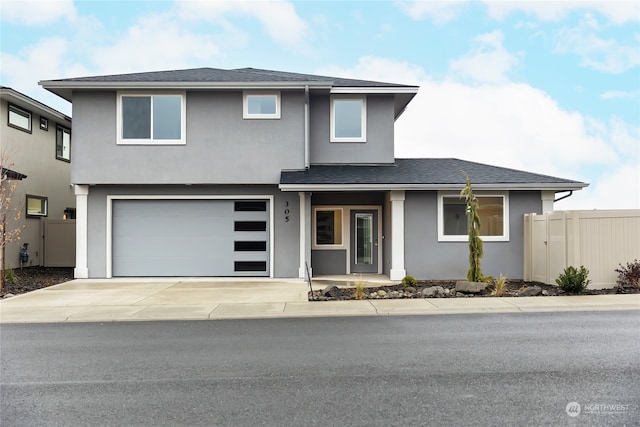 view of front of home with stucco siding, a shingled roof, concrete driveway, fence, and a garage